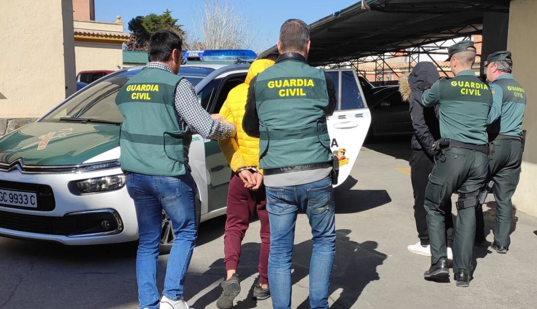 Agentes de la Guardia Civil conducen a los detenidos al vehículo.