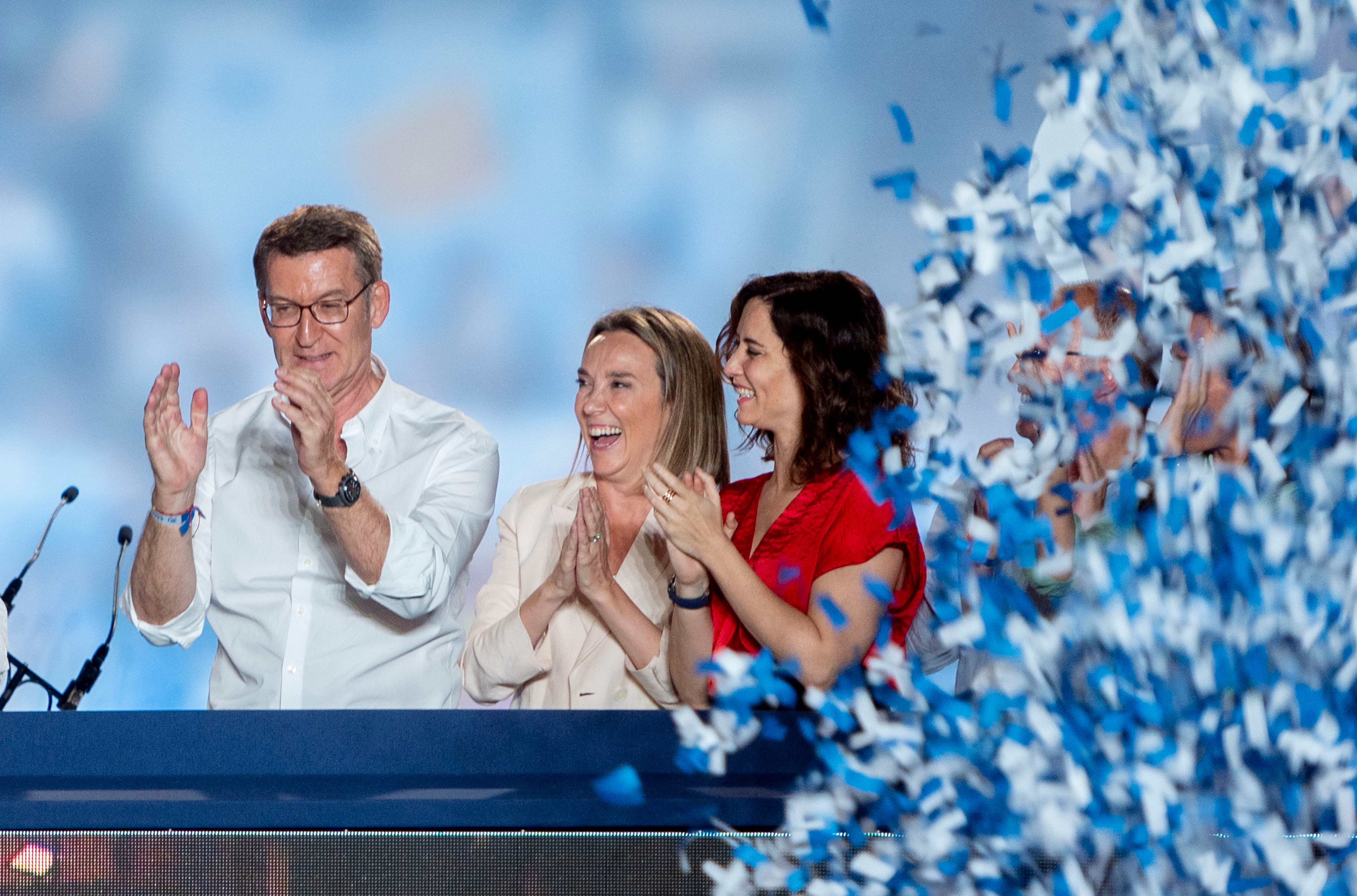 El presidente del PP, Alberto Núñez Feijóo (i), junto a la portavoz Cuca Gamarra (c) y la presidenta madrileña, Isabel Díaz Ayuso, (d), durante la celebración en Génova en la noche electoral.