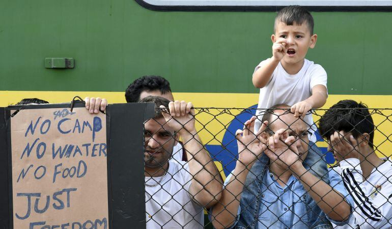 Refugiados resisten junto al tren que permanece varado en la estación ferroviaria de Bicske (Hungría).