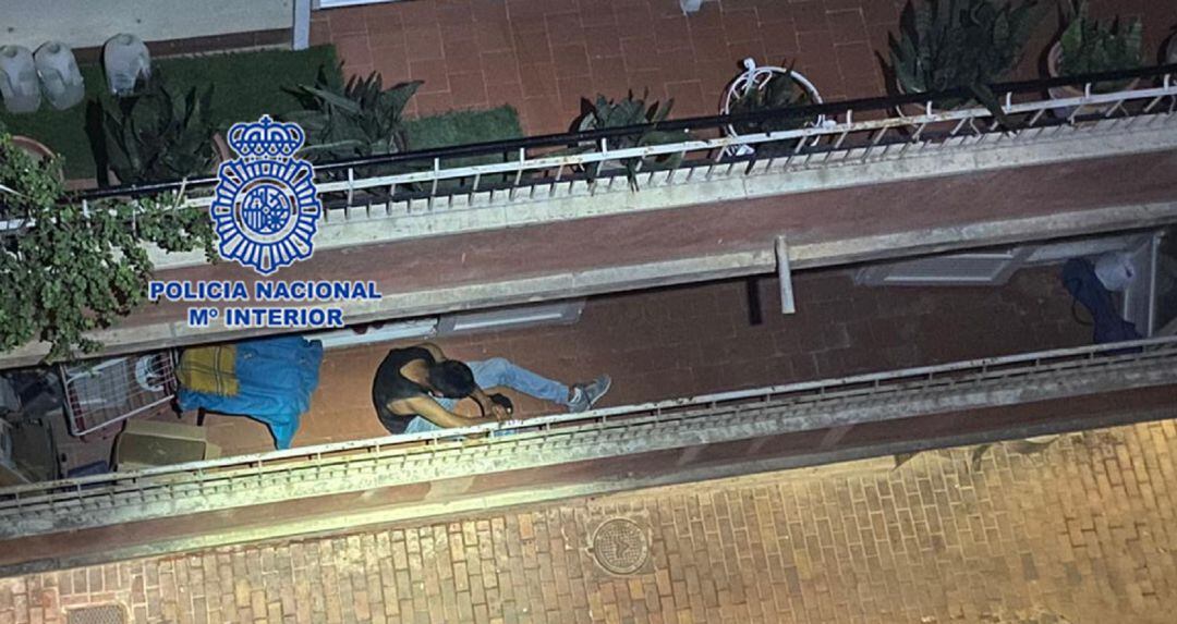 Imagen de uno de los presuntos ladrones agazapado en un balcón para intentar no ser localizado por los agentes policiales