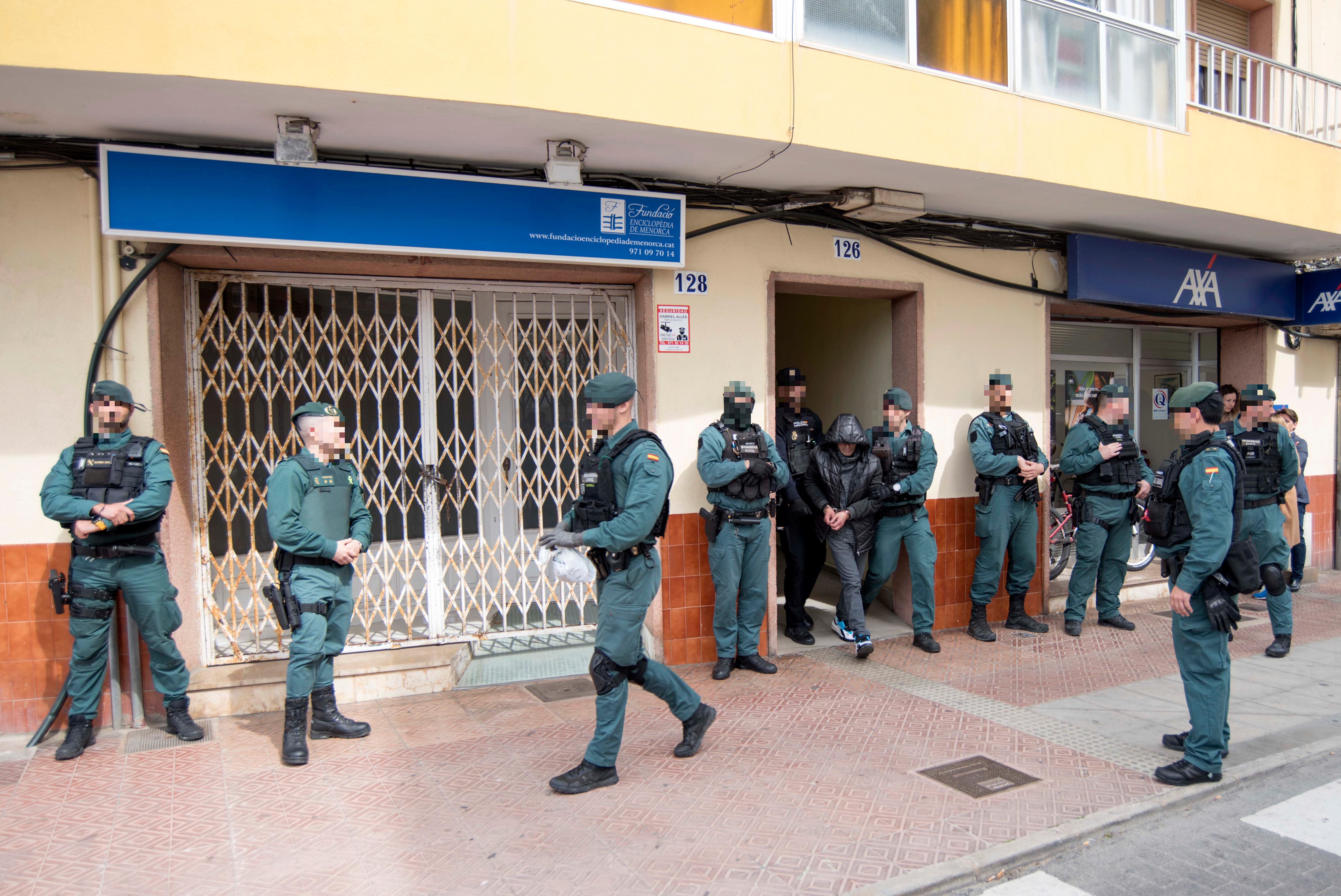 MAHÓN (MENORCA), 24/03/2023.- Un detenido es conducido por los efectivos de la Policía Nacional y de la Guardia Civil este viernes en la calle de Sant Manuel de Mahón, donde llevan a cabo desde primera hora de la madrugada de este viernes una amplia operación contra el tráfico de drogas en Mahón, han confirmado fuentes policiales. EFE/ David Arquimbau Sintes
