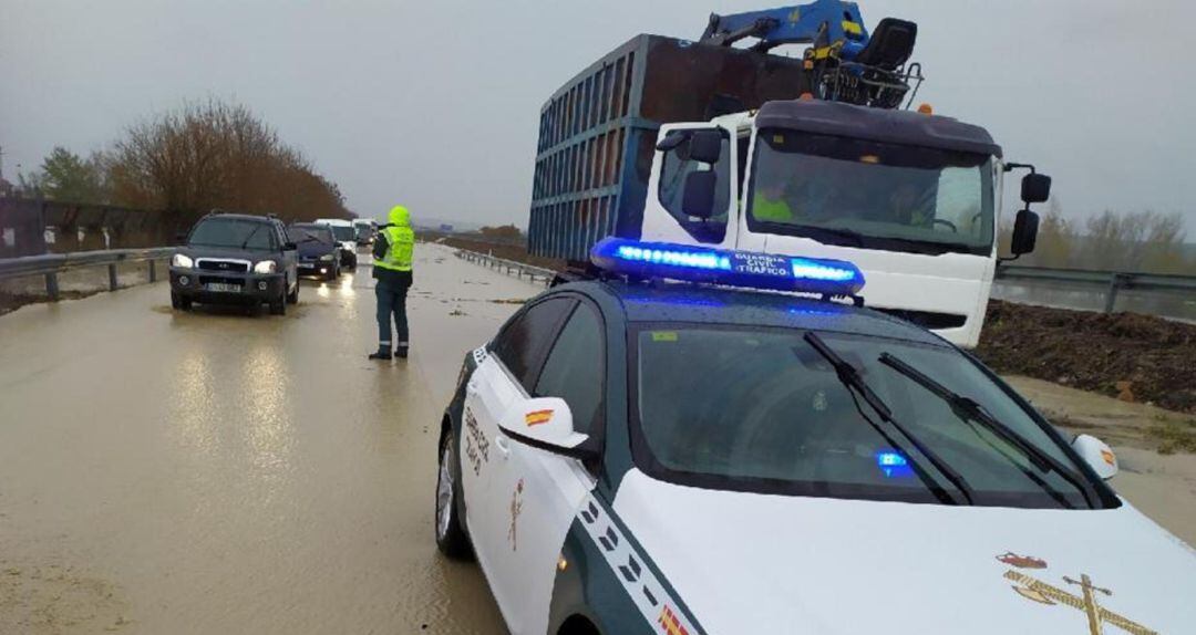 Un agente de la Guardia Civil detiene el tráfico en una de las carreteras de la provincia afectadas por la borrasca &#039;Elsa&#039;.