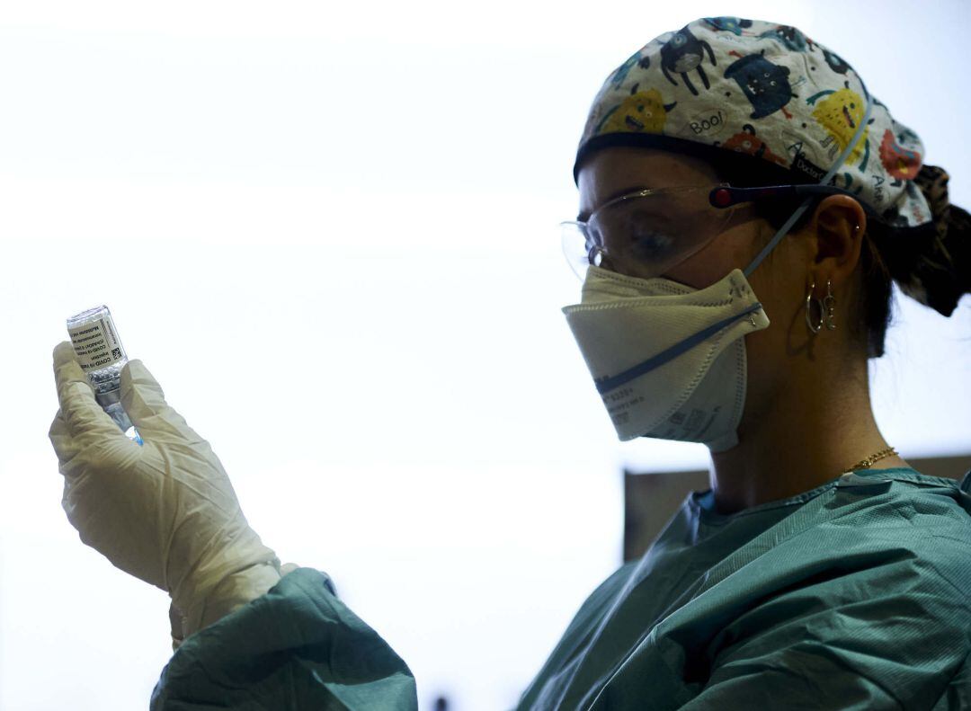 Una profesional sanitaria sostiene un vial con la vacuna del Covid.