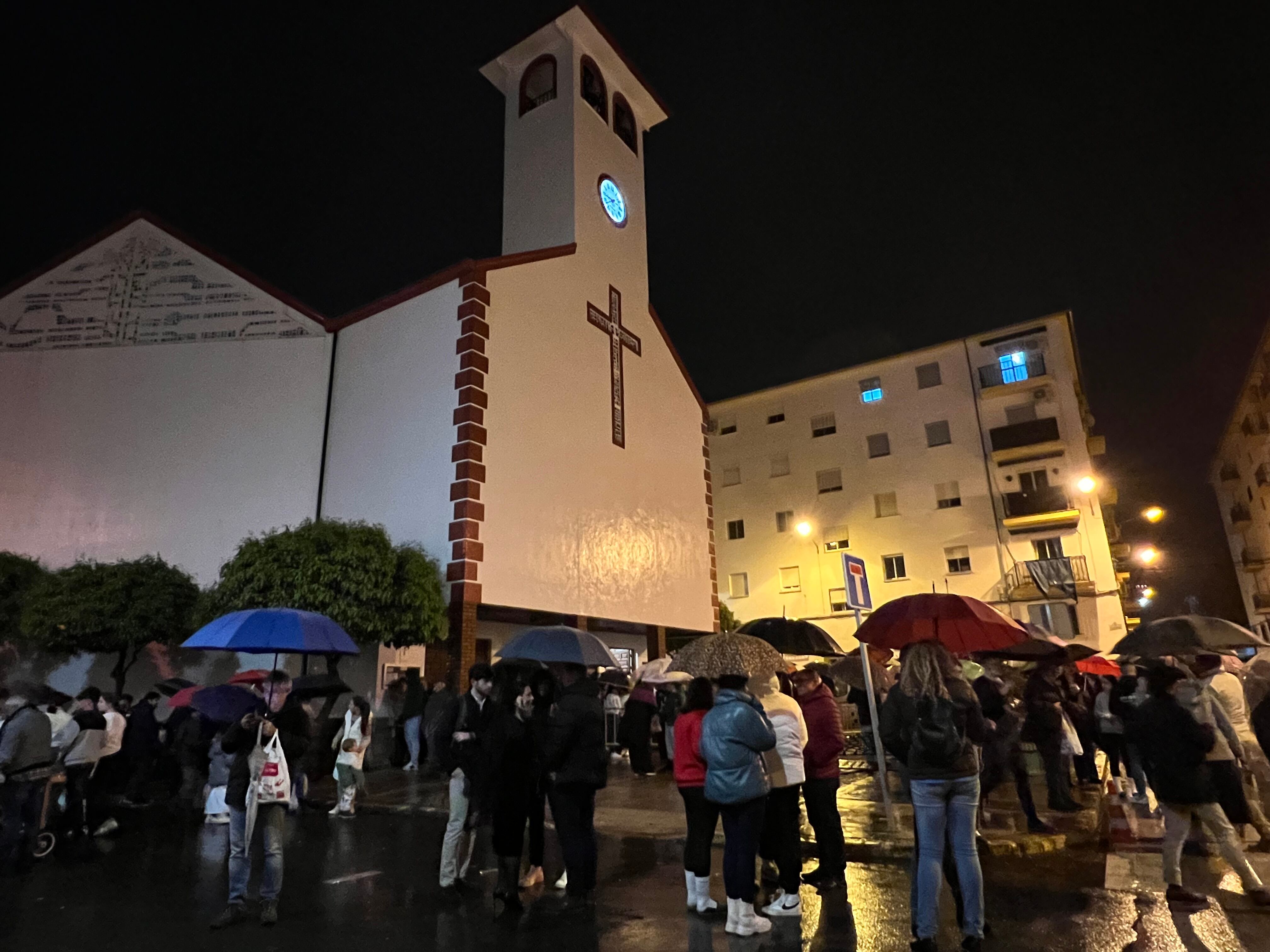 Ciudadanos con sus paraguas abiertos en la puerta de la parroquia de San Cristóbal este Miércoles Santo