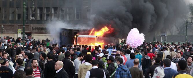 Un coche de policía arde durante los disturbios en la plaza Tahrir