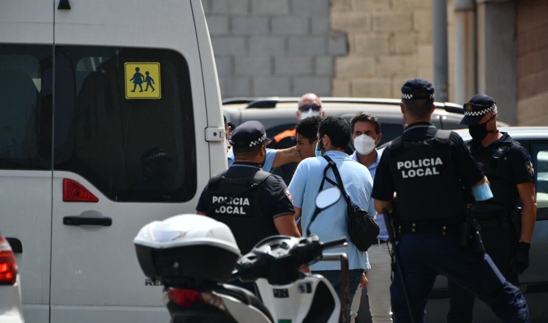 Varios agentes y vehículos de la Policía Local de Ceuta acompañan a menores no acompañados hacia una furgoneta