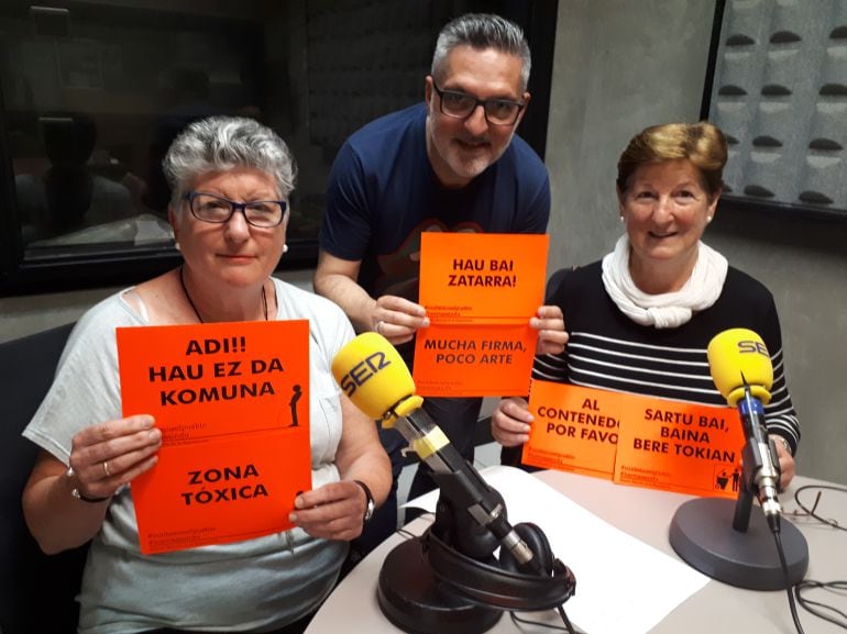 Las integrantes de la 14ª promoción de la Escuela de Experiencia Rosa Agirreazaldegi y Enriqueta Zaballa, junto a Juanma Cano, posan con algunas de las pegatinas que colocarán en las calles