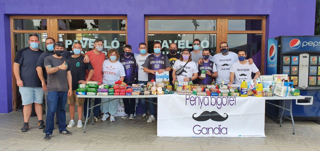 La Penya Bigotet y la directiva del club junto a los alimentos recogido en la campaña solidaria