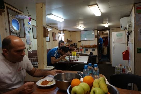 El capitánde Dignity I (a la izquierda), almuerza junto a tres marineros de la embarcación.