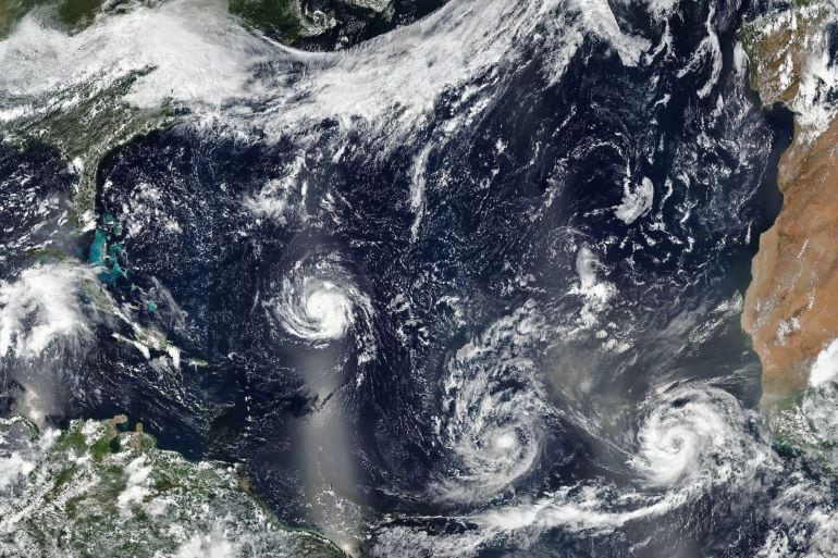 Imagen facilitada por la NASA que muestra los huracanes (i-d) Florence, Isaac y Helene avanzando por aguas del Atlántico Norte.