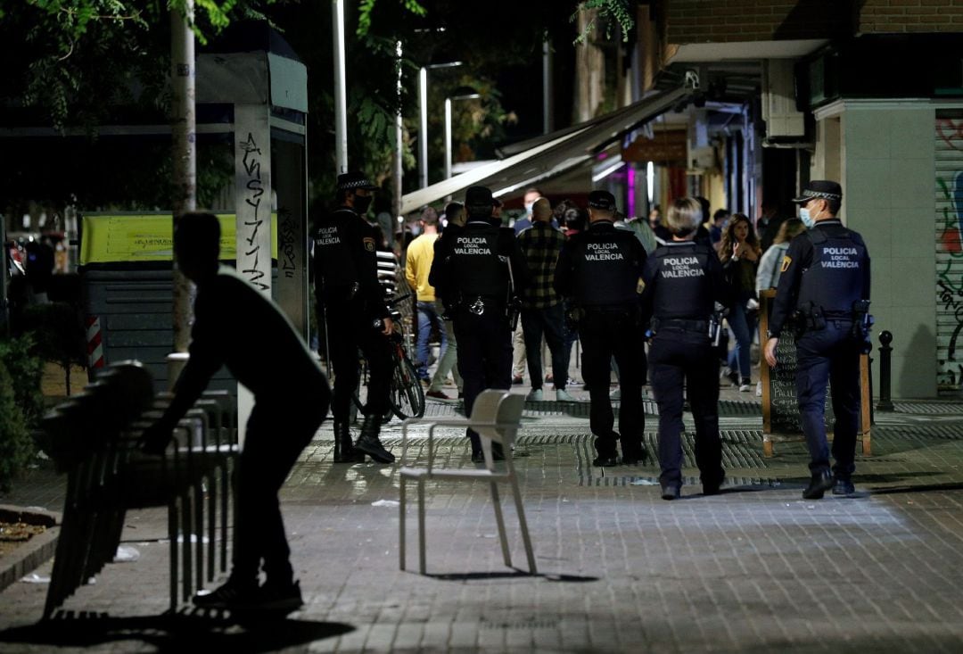 Agentes de la Policía Local de Valencia recorren las terrazas de una conocida zona de ocio de la ciudad vigilando que se cumplen los horarios de cierre y las medidas ante la covid-19 a poco minutos de la entrada en vigor del toque de queda.