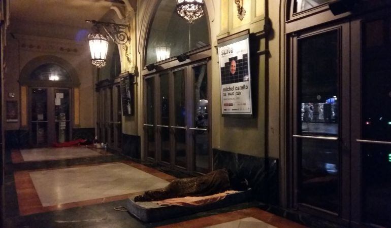 Una persona sense llar dormint a les portes del Teatre Liceu