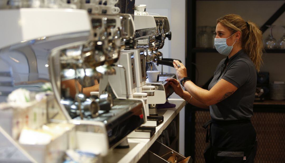 Una camarera sirviendo café en un bar.