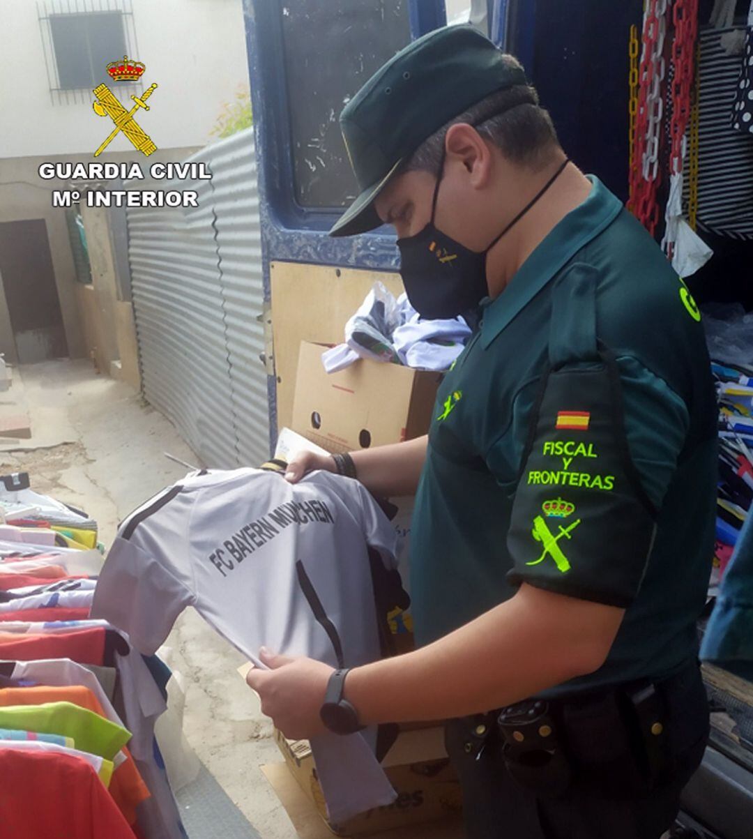 Un agente observa una de las camisetas intervenidas.