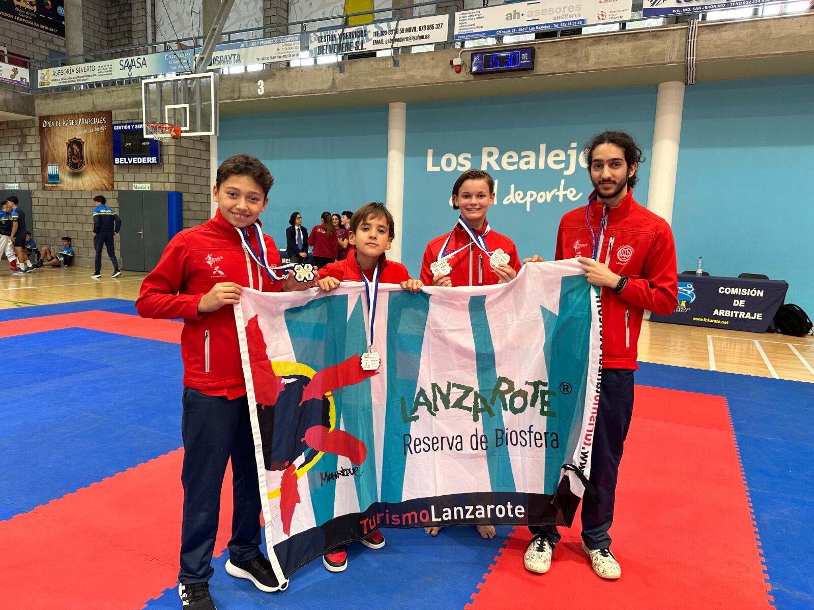 Karatekas del club Poliarrecife con sus medallas y su entrenador.