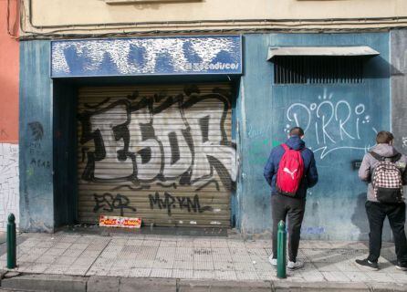 Unos jóvenes miran la puerta del bar a cuyas puertas fue agredido Víctor Laínez
