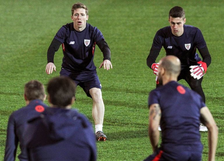 Los jugadores Iker Muniain (i) y Kepa Arrizabalaga (d) calientan durante el entrenamiento que el Athletic ha celebrado hoy para preparar el encuentro de mañana, correspondiente a la Liga Europa, contra el Olympique de Marseille