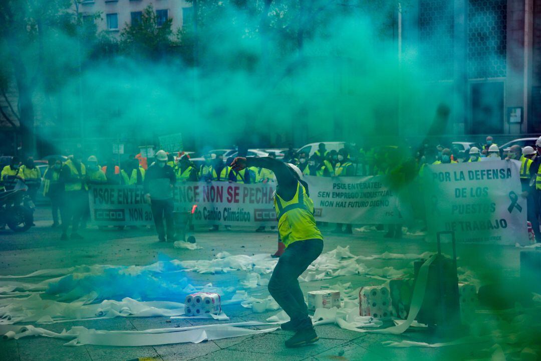 Trabajadores de la factoría pontevedresa de ENCE se concentran con chalecos amarillos, pancartas, tirando rollos de papel higiénico y rodeados de humo verde en las inmediaciones del Ministerio de Transición Ecológica en Madrid 