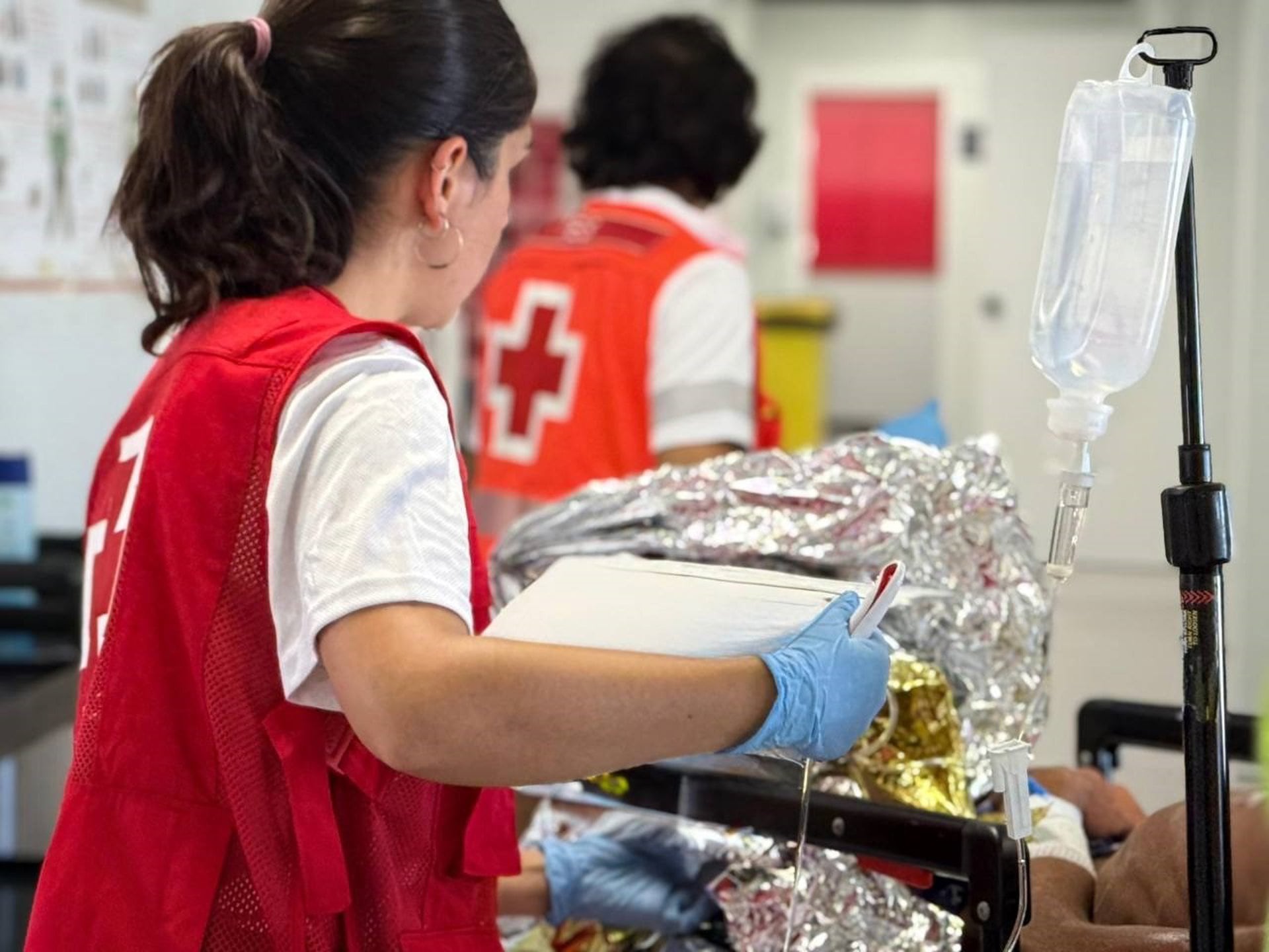 Una voluntaria de Cruz Roja atiende a los hombres llegados en patera a Alicante