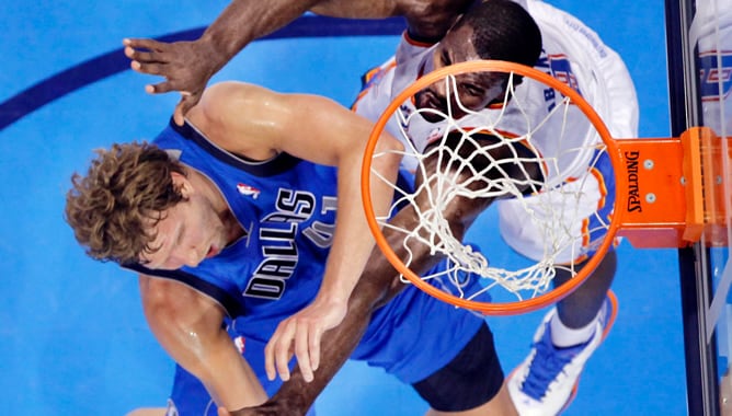 El jugador alemán de los Mavericks Dirk Nowitzki disputa un rebote con el componente de la selección española Serge Ibaka