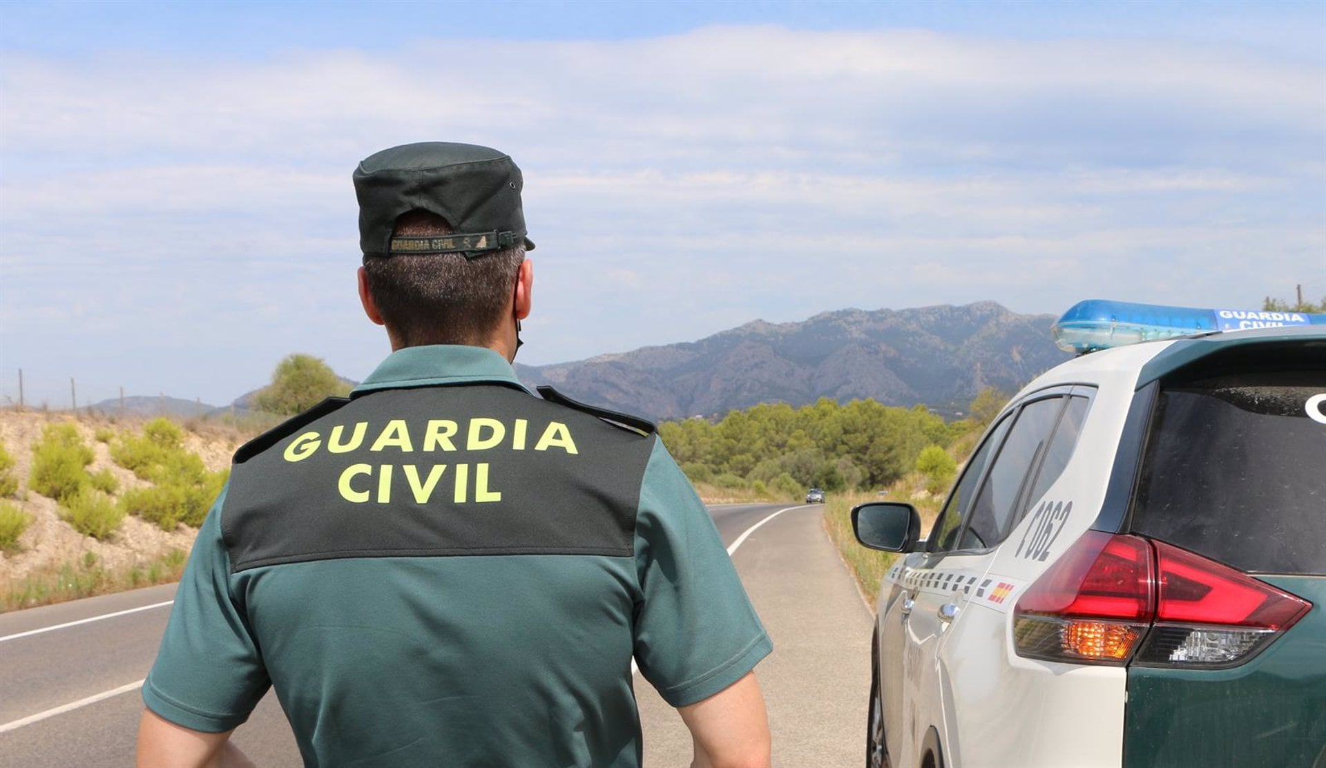 Agente de la Guardia Civil junto a un vehículo