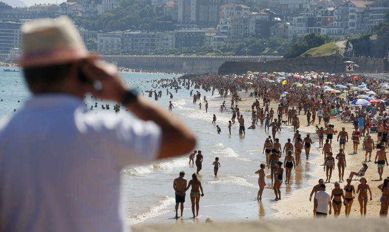 Vista de la playa de Ondarreta de San Sebastián abarrotada de bañistas coincidiendo con el horario de la pleamar.