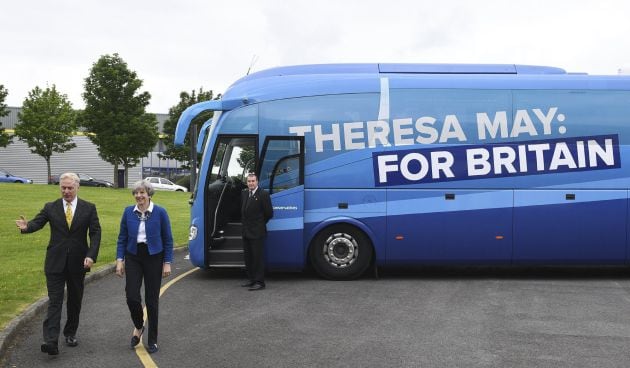 La primera ministra británica, Theresa May (2i) a su llegada a una visita a una fábrica textil durante un acto de campaña electoral en Accrington, Lancashire, Reino Unido