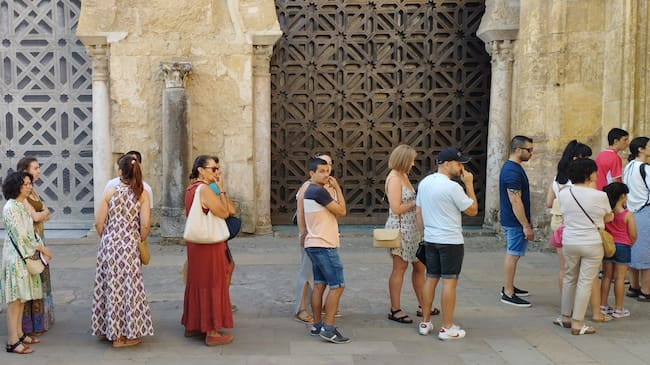 Una multitud de personas hace cola para visitar la Mezquita de Córdoba, que ha reabierto este sábado después del incendio sufrido el viernes.