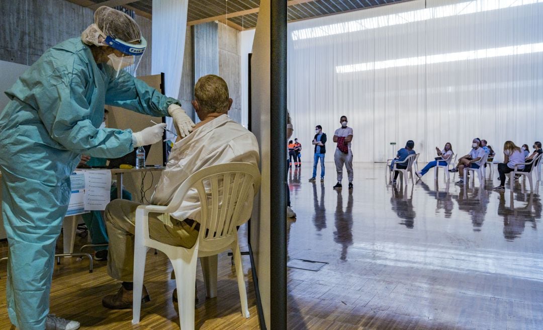 Una sanitaria inoculando una dosis de la vacuna contra la COVID-19.