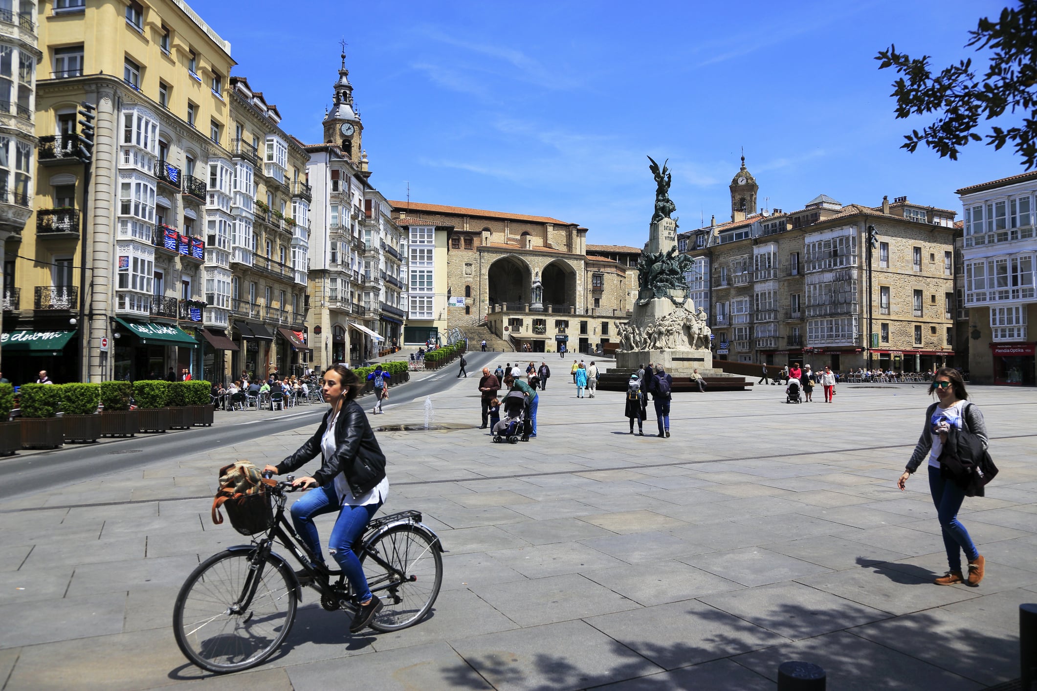 Un mujer en bicicleta en la Plaza de la Virgen Blanca