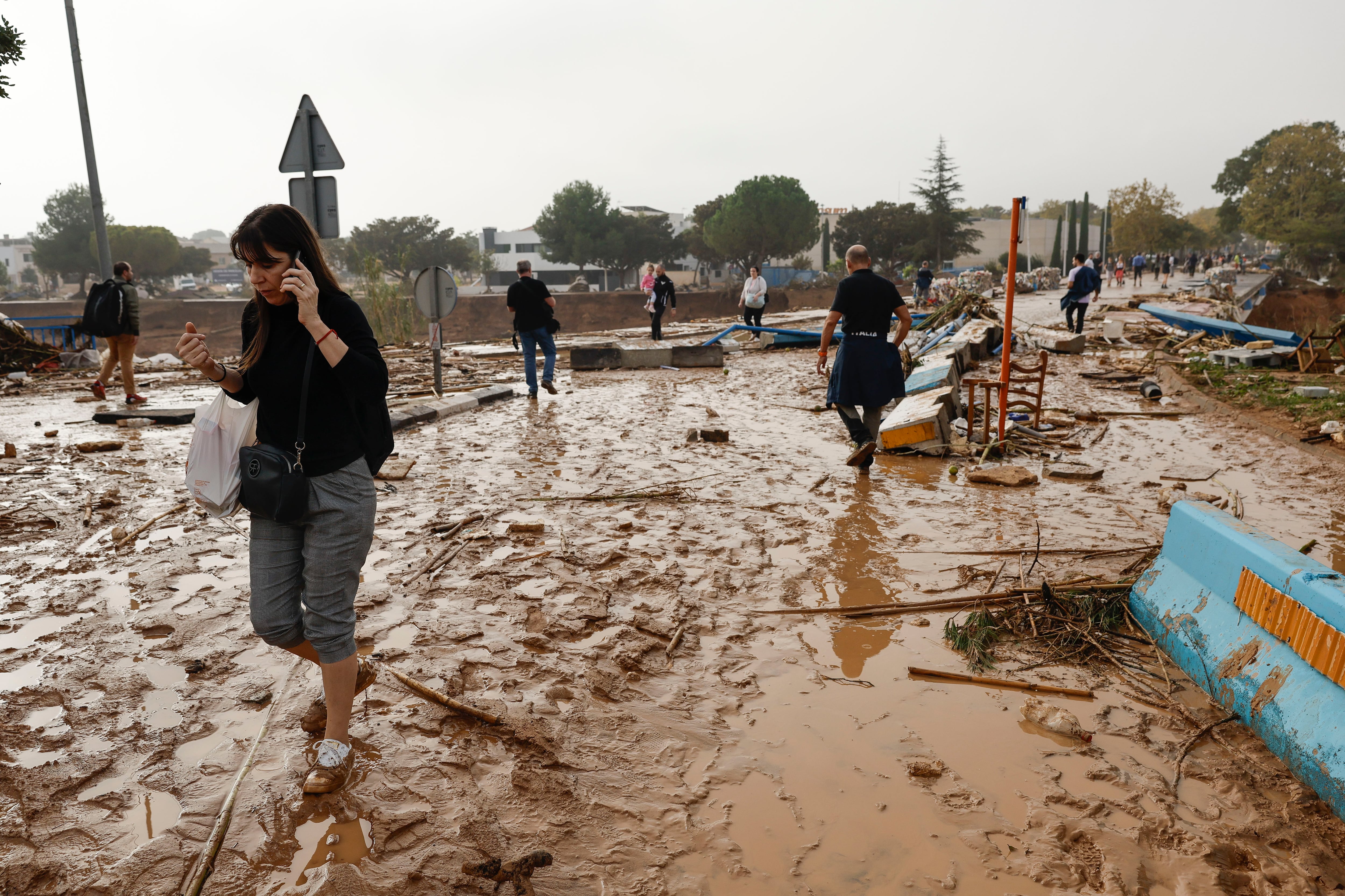 PICAÑA (VALENCIA), 30/10/2024.- Una mujer camina entre el lodo acumulado por las intensas lluvias de la fuerte dana que afecta especialmente el sur y el este de la península ibérica, este miércoles en Picaña (Valencia). EFE/Biel Aliño
