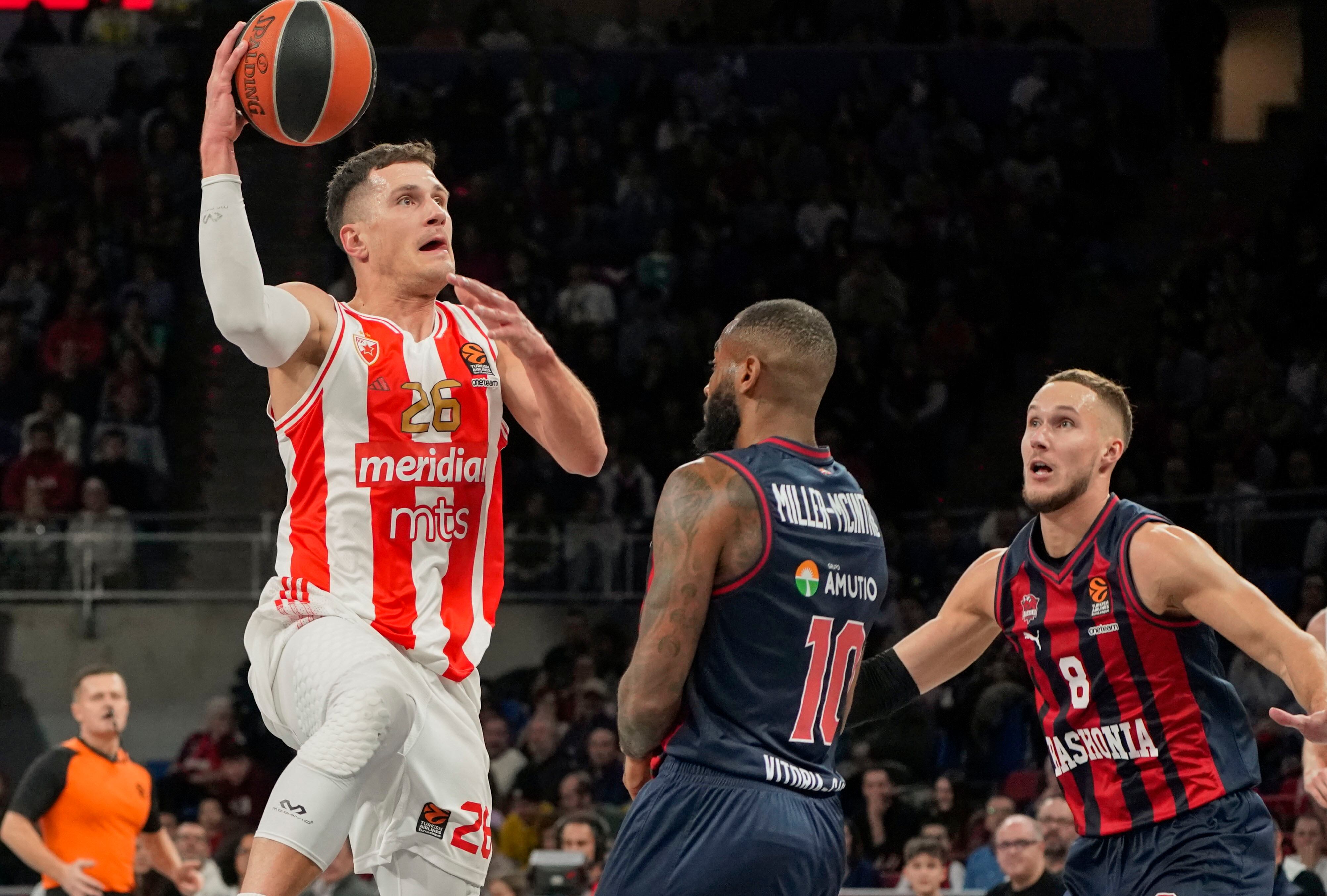 Codi Miller-McIntyre (c) y el alero lituano Tadas Sedekerskis (d) defienden a Nemanja Nedovic, base serbio del Estrella Roja, durante el encuentro de Euroliga en el pabellón Fernando Buesa Arena en Vitoria.