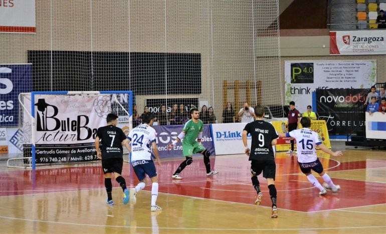 Chema Mella, portero del Santiago Futsal intenta evitar un lanzamiento de diez metros de Nano Modrego, del Zaragoza