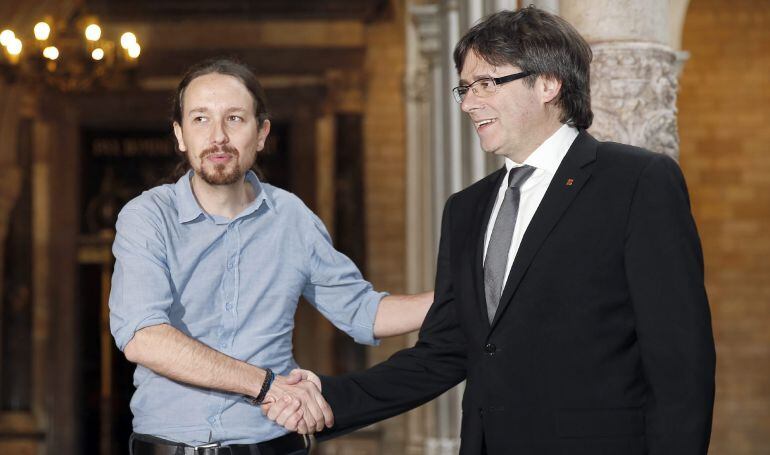 El presidente de la Generalitat, Carles Puigdemont  saluda al líder de Podemos, Pablo Iglesias.