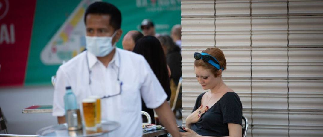 Un camarero sirve en la terraza de un bar 