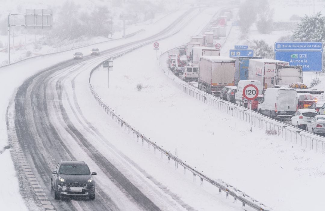 Un coche conduce por una vía completamente nevada.