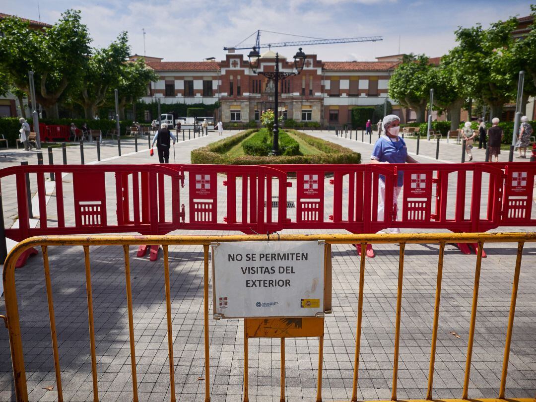 Una trabajadora sanitaria de la ‘Casa de Misericordia’ protegida con mascarilla en el exterior del centro donde han habilitado una zona de visitas para residentes y familiares