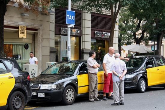 Un grup de taxistes esperen passatge a la parada situada a la cruïlla de Travessera de Gràcia-Bailén
