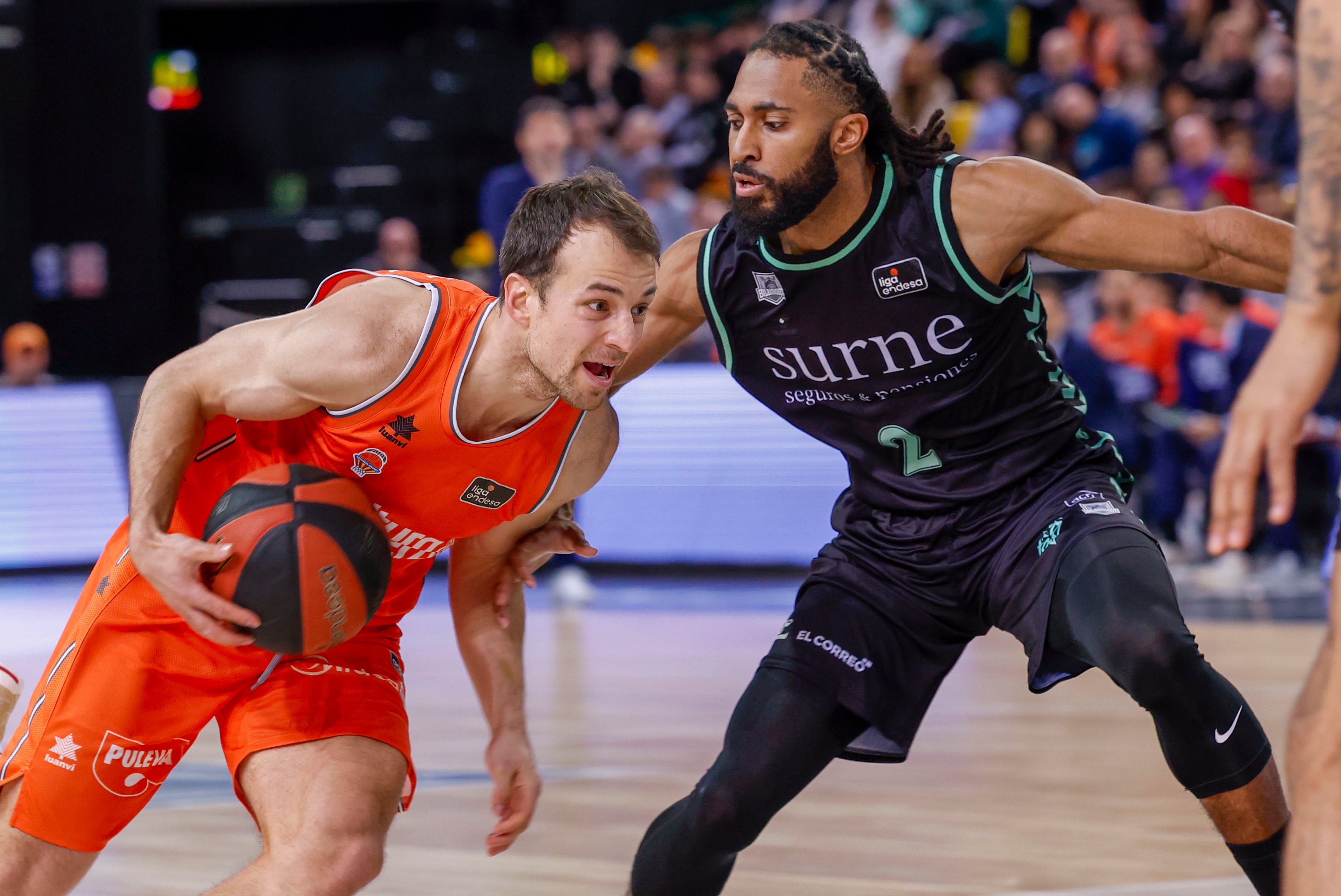 BILBAO, 11/02/2024.- El base del Surne Bilbao Adam Smith (d) defiende ante el base del Valencia Basket Kevin Pangos (i), durante el partido de Liga ACB de baloncesto disputado este domingo en el Bilbao Arena. EFE/Miguel Toña
