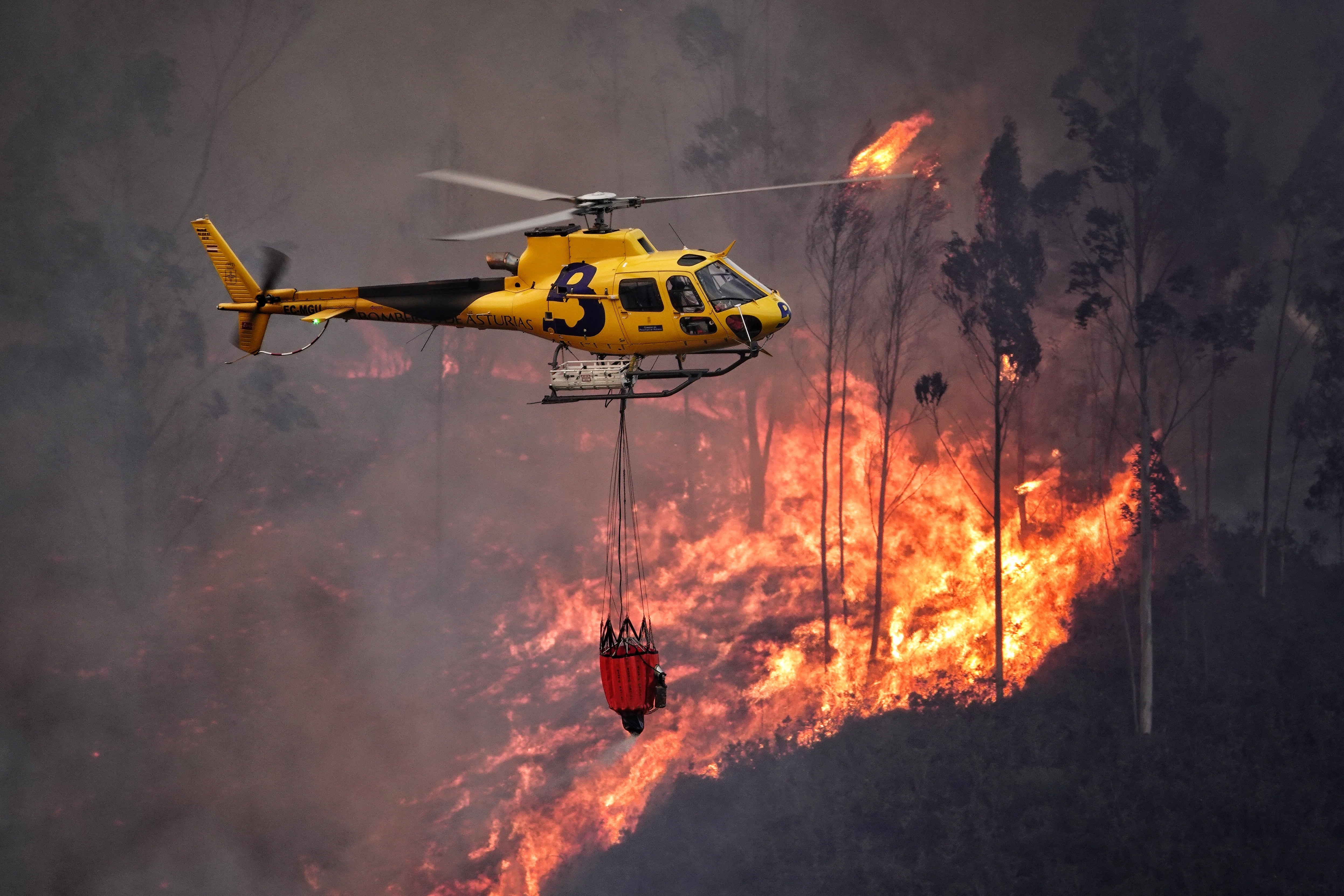 Un helicóptero realiza labores de extinción en los incendios de Asturias