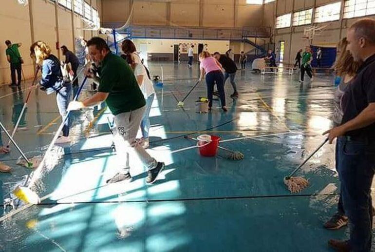 Padres y voluntarios echaron mano de fregonas para secar la pista