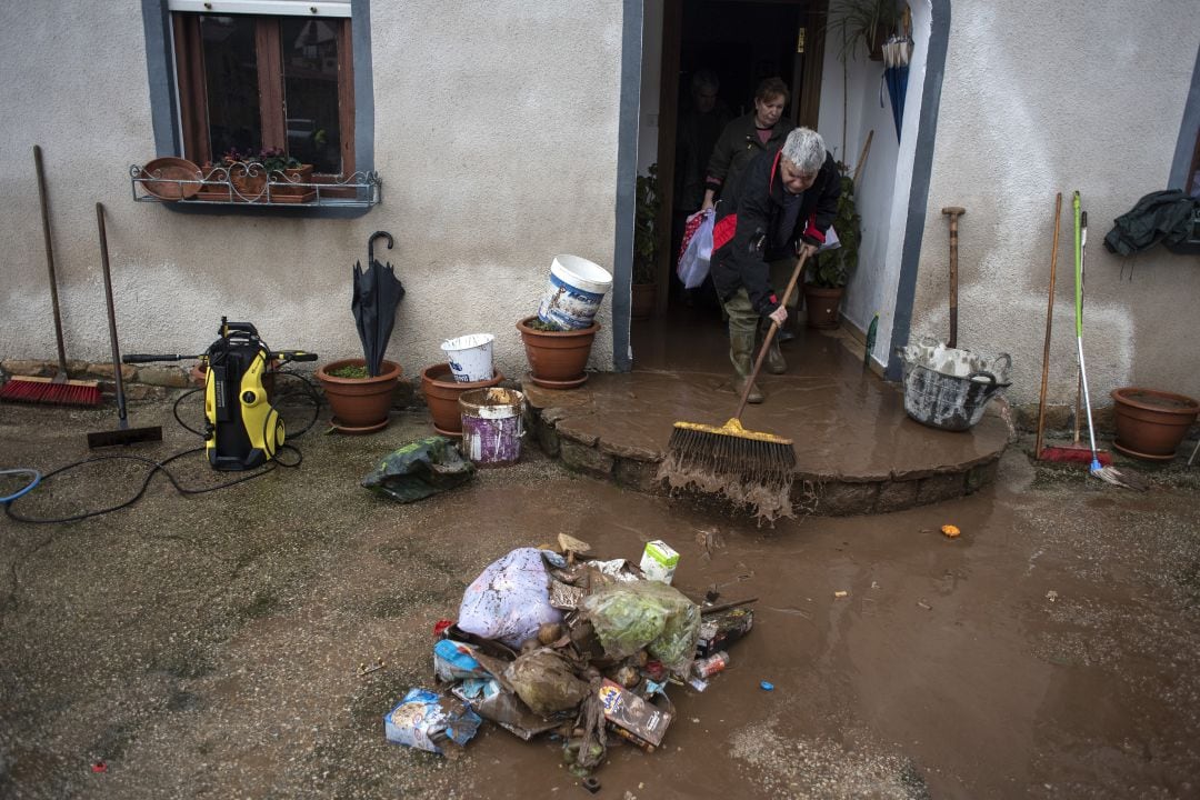 Vecinos de Villanueva de la Peña limpian su vivienda tras las inundaciones que se produjeron en enero de 2019.