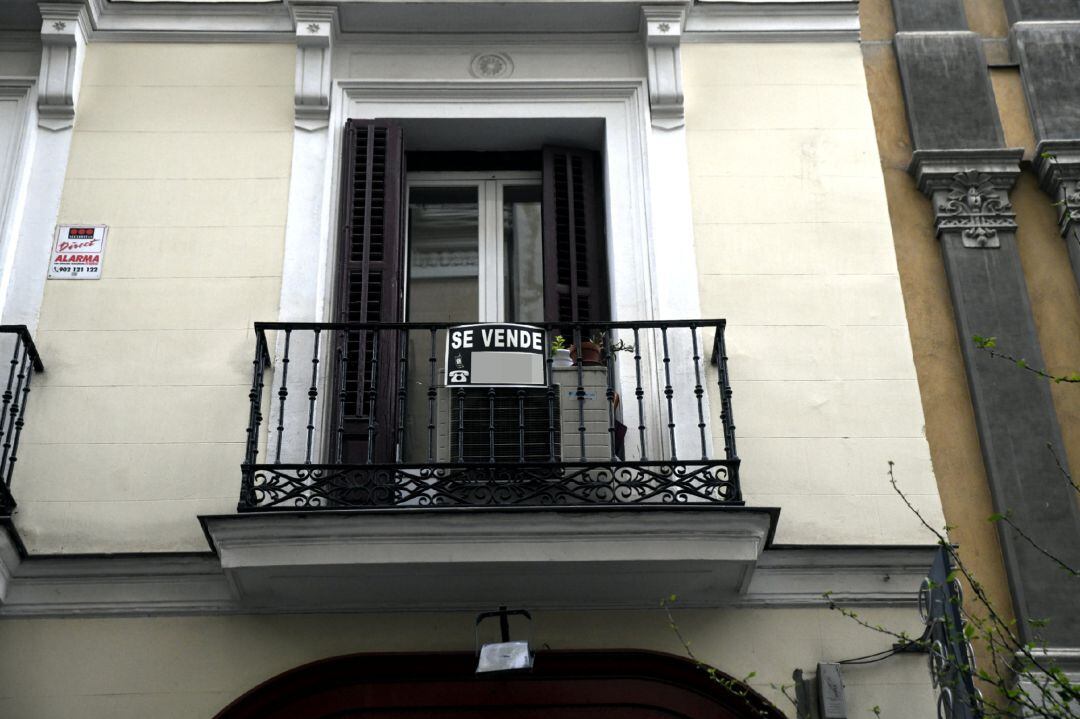 Cartel colgado en un edificio que indica que el inmueble está en venta.