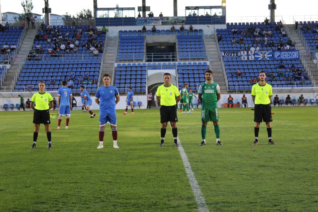 Los capitanes de ambos equipos posando con el trío arbitral