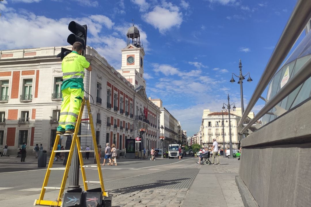 Un trabajador municipal retira un semáforo de la Puerta del Sol que ha cerrado el paso al tráfico