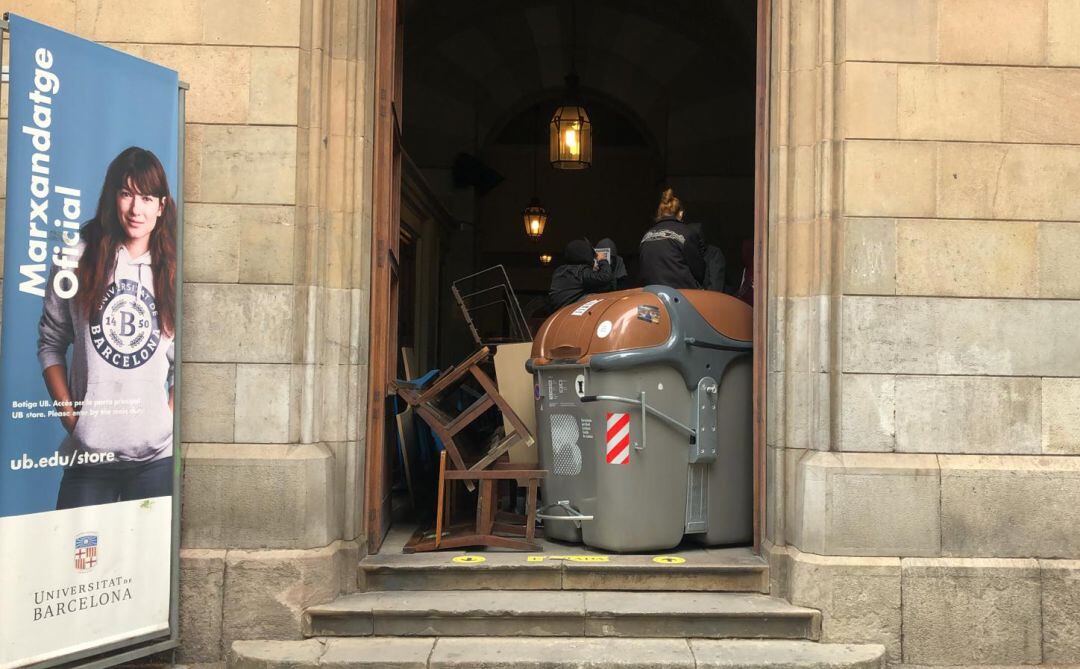 El centenar de joves ha bloquejat amb cadires i contenidors l'accés a l'edifici històric de la Plaça Universitat de Barcelona