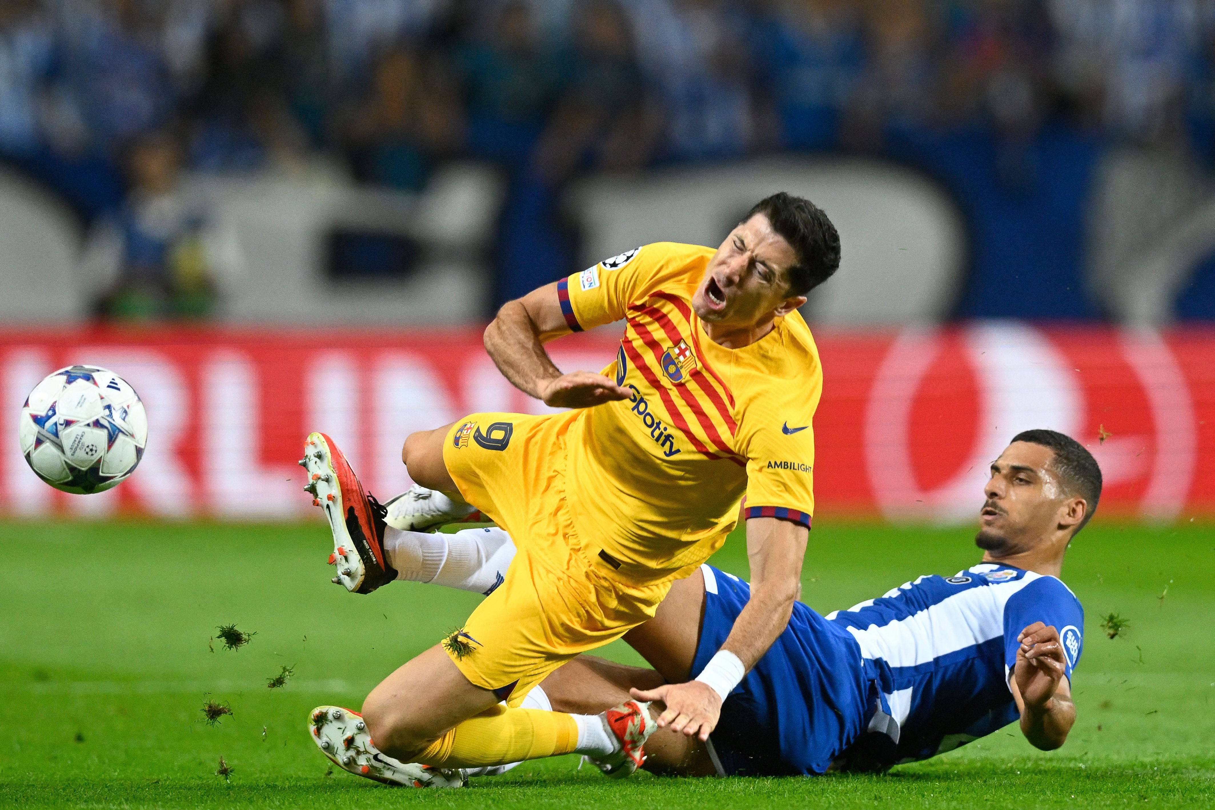 Barcelona's Polish forward #09 Robert Lewandowski (L) is tackled by FC Porto's Portuguese defender #04 David Carmo during the UEFA Champions League 1st round day 2 group H football match between FC Porto and FC Barcelona at the Dragao stadium in Porto on October 4, 2023. (Photo by Patricia DE MELO MOREIRA / AFP) (Photo by PATRICIA DE MELO MOREIRA/AFP via Getty Images)