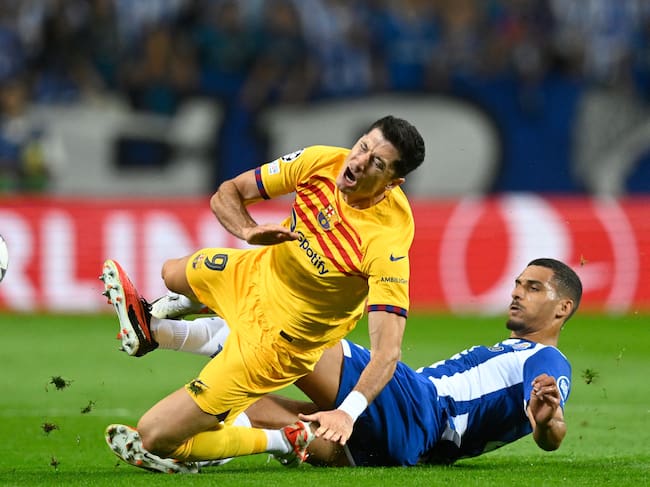 Barcelona's Polish forward #09 Robert Lewandowski (L) is tackled by FC Porto's Portuguese defender #04 David Carmo during the UEFA Champions League 1st round day 2 group H football match between FC Porto and FC Barcelona at the Dragao stadium in Porto on October 4, 2023. (Photo by Patricia DE MELO MOREIRA / AFP) (Photo by PATRICIA DE MELO MOREIRA/AFP via Getty Images)