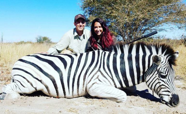 Jaycee Carroll y su mujer, junto a un Cebra en un safari