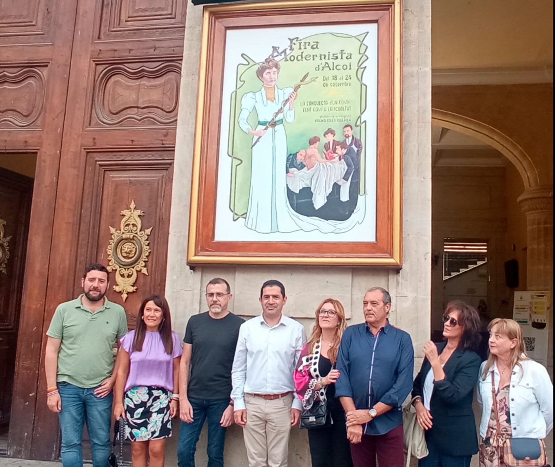 El autor, Michel Abiétar, junto a familiares y autoridades, bajo el cartel de la Feria Modernista